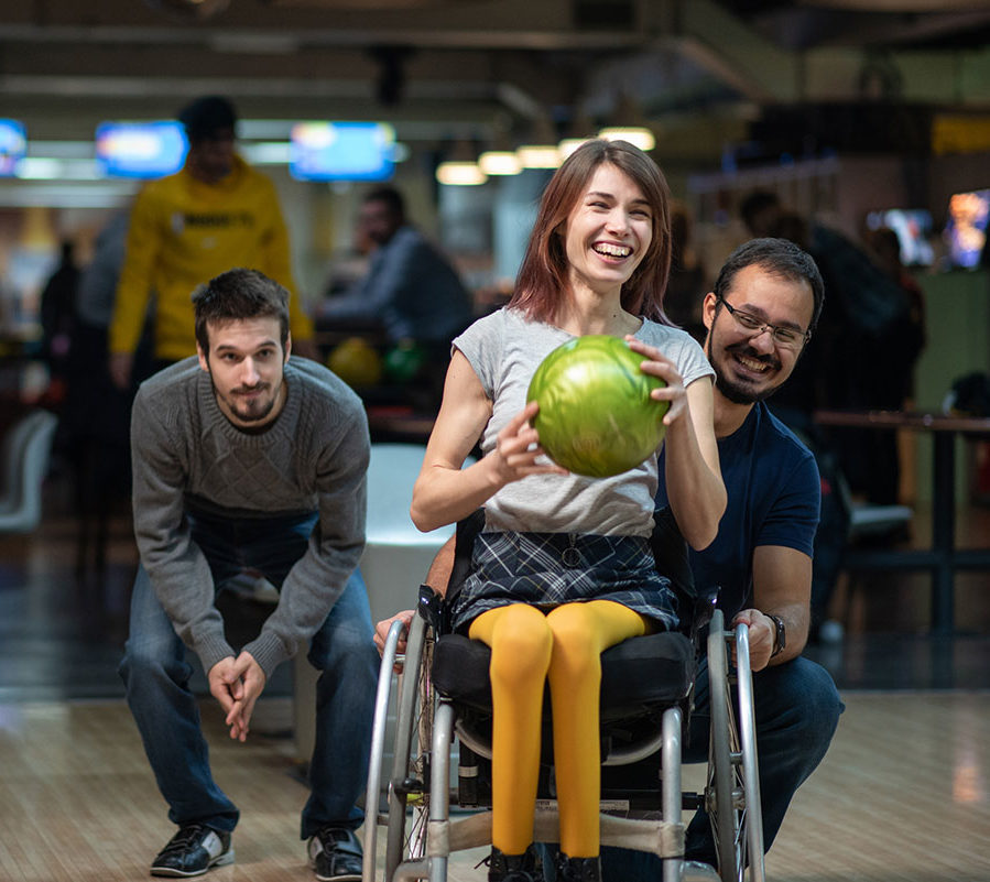 Woman in a wheelchair bowling with 2 others